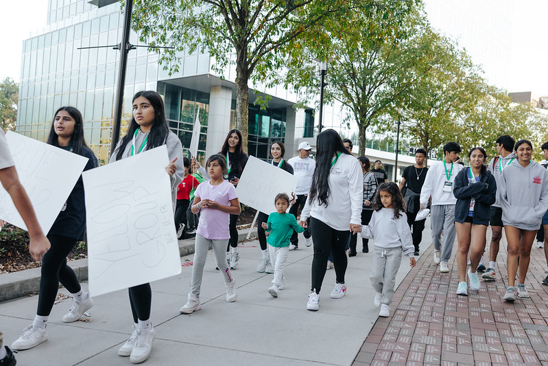 A group of supporters walk while carrying signs